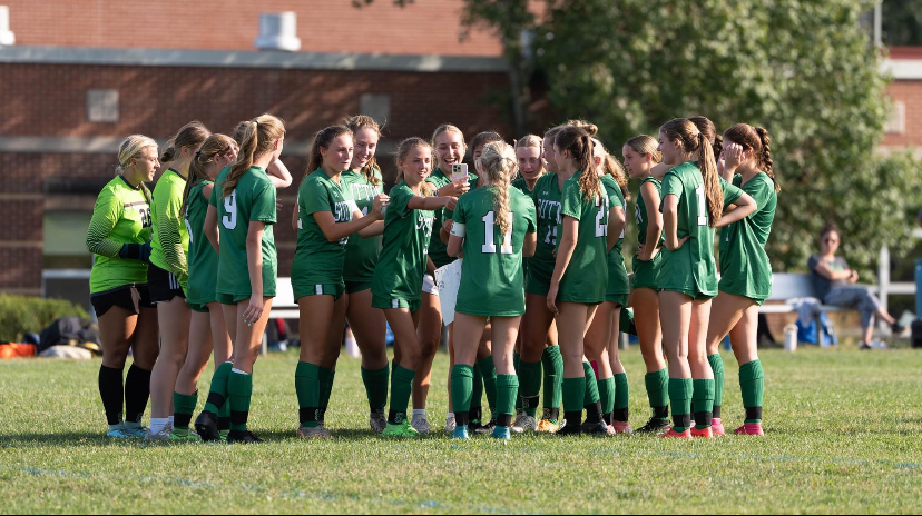 Here the soccer team huddles up during their game.