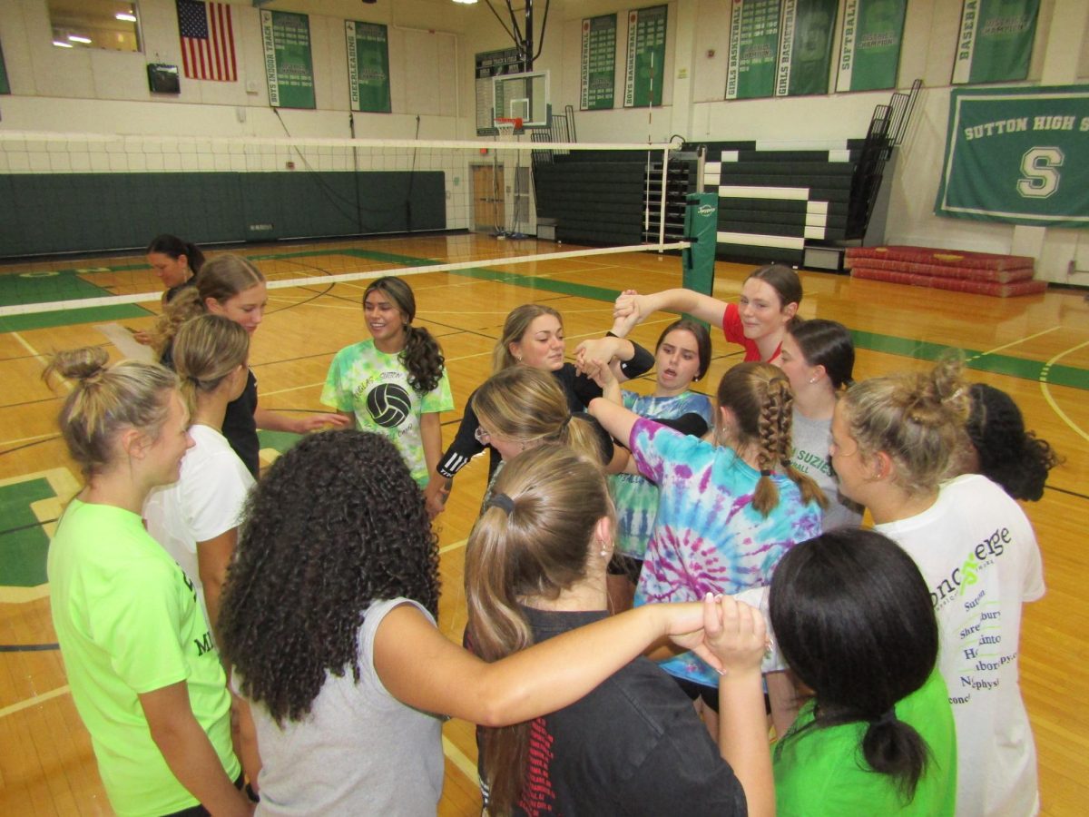 The volleyball team participates in a team building activity before practice.