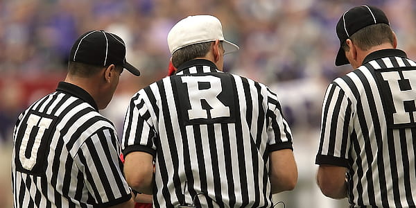 Three Refrees meeting in the middle before the start of a game. 