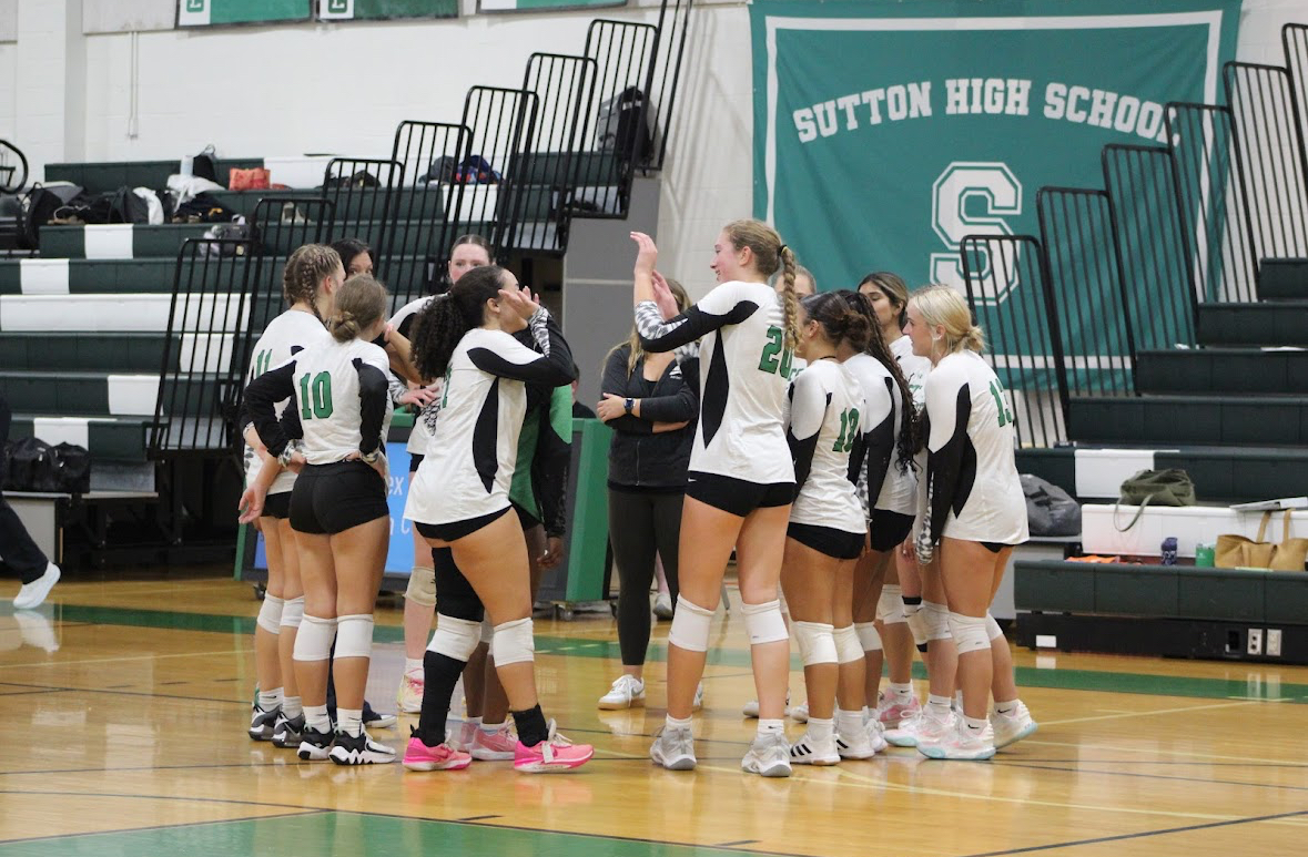 Varisty Volleyball huddles during their game on Friday against Douglas.