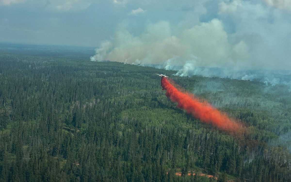 A water bomber drops a load of fire retardent as smoke rises from the Sousa Creek wildfire HWF036 east of Rainbow Lake, Alberta, Canada in an aerial photograph June 2, 2025.  Alberta Wildfire/Handout via REUTERS.   THIS IMAGE HAS BEEN SUPPLIED BY A THIRD PARTY