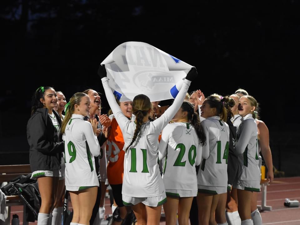 The Suzies' Field Hockey Team advances to the Final Four as Claire Acocelli holds up the new Final Four Poster.